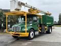 A green and yellow 2015 Freightliner M2 106 bucket truck with a raised hydraulic lift and a utility body for maintenance work