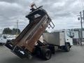 A 2008 Mitsubishi Fuso FE180 truck with its dump bed raised showing the steel bed and hydraulic lift mechanism