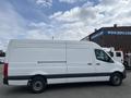 A white 2025 Mercedes-Benz Sprinter van with a long cargo area and black accents on the sides