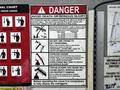 A 2016 Ford F-550 pickup truck with a mounted crane and safety warning signs for operating the equipment safely