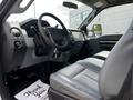Interior of a 2016 Ford F-550 featuring a steering wheel dashboard and gray seating with a floor mat saying Thank You