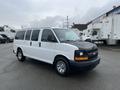 A white 2012 Chevrolet Express van with a black hood and chrome wheels parked at an angle