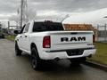 A white 2022 RAM 1500 Classic pickup truck viewed from the rear showcasing its bold RAM logo and dual exhausts