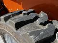 A close-up of a tire from a 2017 Gehl R105 featuring deep treads and a textured surface showcasing wear and tear