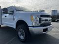 A 2017 Ford F-350 Super Duty with a white exterior and chrome front grille featuring round headlights and large tires