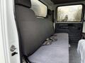 A gray upholstered seat inside a 2015 Isuzu NPR HD truck with seatbelt visible and a simple interior design