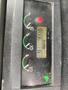 Control panel of a 2012 John Deere 310SJ showing gauges for fuel, engine temperature, and hydraulic pressure along with an indicator light and numerical reading