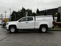 A white 2019 Chevrolet Colorado pickup truck with a covered bed parked on a concrete surface