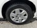 A close-up of a silver alloy wheel on a 2011 Dodge Grand Caravan featuring six spokes and a black tire with visible tread patterns