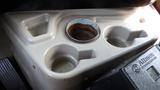 A beige cup holder designed for a 2003 International 5600i with three circular indentations and a central metallic ring showing signs of rust
