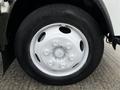 Close-up of a white wheel and tire on a 2018 Isuzu NRR with a smooth tread pattern and visible lug nuts
