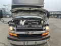 A 2017 Chevrolet Express with its hood opened revealing the engine compartment and various mechanical components