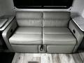 A light gray sofa with two cushions and armrests designed for a 2022 Aspen Trail camper interior