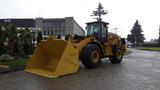 A 2019 Caterpillar 972M XE wheel loader with a large yellow scoop bucket parked on an industrial road