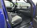 Interior view of a 2022 Toyota Tacoma showing the front seats dashboard and gear shift with gray upholstery and a touchscreen display