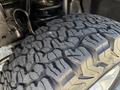 Close-up of a rugged tire from a 2014 Ford F-250 SD showcasing its deep tread pattern designed for off-road performance