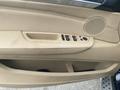 Interior view of a 2009 BMW X5 door panel featuring tan leather upholstery window controls and a speaker