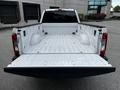 A 2017 Ford F-250 with an open truck bed showing a clean white interior design and the tailgate lowered