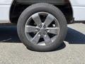 A 2014 Ford F-150 aluminum wheel with five spokes and a black tire mounted on it