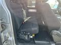 The interior of a 2014 Ford F-150 features black fabric seating with a spacious back seat and a simple layout for storage and comfort
