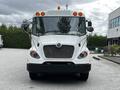 A 2015 Spartan School Bus with a white exterior large front grille and multiple amber lights on the roof
