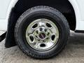 A chrome wheel with the GMC logo mounted on a rugged tire with deep treads