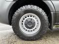 Close-up of a rugged tire mounted on a 2022 Mercedes-Benz Sprinter showing a silver rim and textured tread designed for off-road use