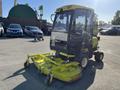 A 2010 Kubota F3990 is shown from the back featuring a yellow mowing deck and an enclosed cab with a black frame