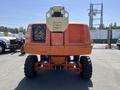 A 2008 JLG Boom Lift in orange with large rubber tires and a raised platform for elevated access work
