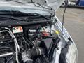 A 2010 Ford Transit Connect with its hood open revealing the engine compartment including the battery and various engine components