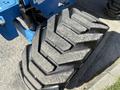 Close-up of a large rubber tire with a deep tread pattern designed for heavy machinery use