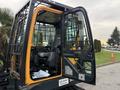 A 2022 Hyundai R55-9A excavator with its door open showcasing the operator's seat and controls inside the cabin