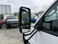 A 2020 Chevrolet Express van with a side mirror visible in the foreground