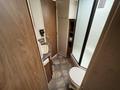 Interior of a bathroom in a 2013 Outdoor Wind River featuring a toilet a sink and a shower with a glass door
