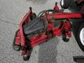 A red Toro Groundsmaster mower deck with wheels and a black engine cover in the foreground
