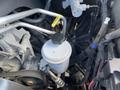 Engine components of a 2011 RAM 1500 including a transparent reservoir with a black cap and various metal pipes and hoses around it