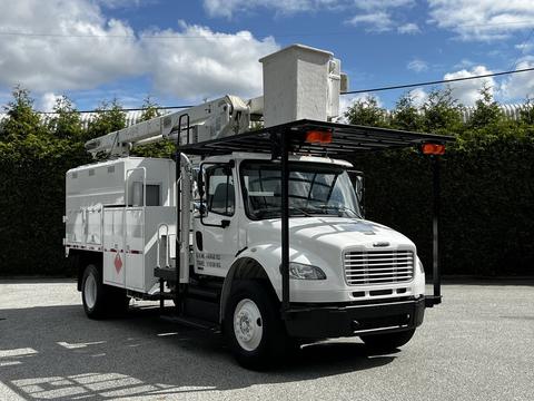 A white 2012 Freightliner M2 106 bucket truck with a raised aerial lift and equipment storage compartments on the side