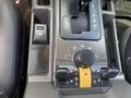 Close-up of the center console of a 2006 Land Rover LR3 featuring gear shift lever and various control knobs and buttons for vehicle settings and features