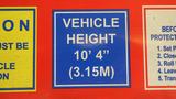 A blue sign displaying the vehicle height as 10' 4'' (3.15m)