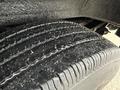 Close-up of a tire from a 2014 GMC Savana showing the tread pattern and small particles embedded in the rubber surface