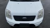 A white 2012 Ford Transit van facing directly towards the viewer with a black grille and headlights visible