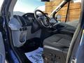 Interior view of a 2017 Ford Transit van featuring a steering wheel front dashboard and driver seat with gray fabric upholstery