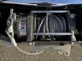 Close-up of a winch mounted on a 2017 Chevrolet Silverado 3500HD featuring a spool of steel cable and a warning label on the base