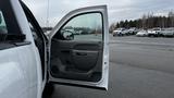 A white 2013 Chevrolet Silverado 1500 with its driver's door open showing the interior door panel and handle