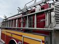 A red and yellow 2009 Spartan Gladiator fire truck featuring metal ladders mounted on top and a shiny silver side panel