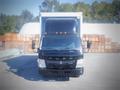 A 2013 Mitsubishi Fuso FE 160 truck facing forward with a black exterior and orange lights on the roof