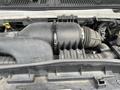 Close-up of the engine compartment of a 2009 Ford Econoline featuring the air intake system and various components including hoses and connectors