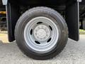 A close-up view of a silver wheel and black tire of a 2022 Ford F-550 with a visible tire tread pattern