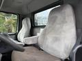 The interior of a 2012 Volvo VNL truck showing two gray fabric seats with armrests and a steering wheel