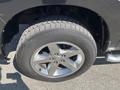 Close-up of the wheel and tire of a 2011 RAM 1500 featuring a shiny chrome rim and a rugged all-terrain tire